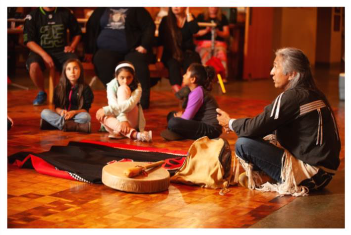 Native youth listening to an Elder’s story