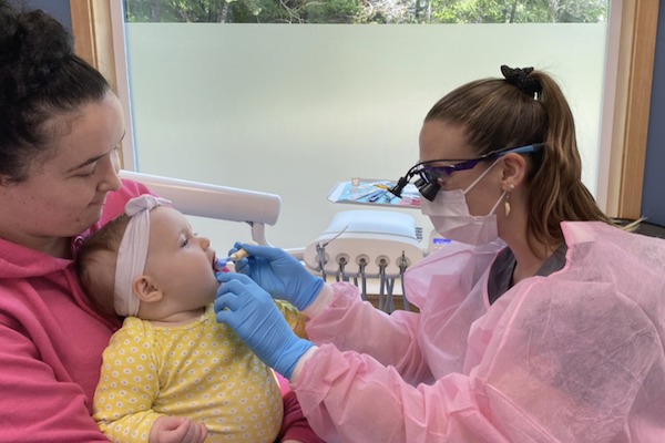 Dentist cleaning a child's mouth