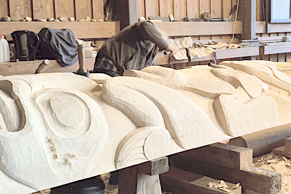Person carving a totem pole